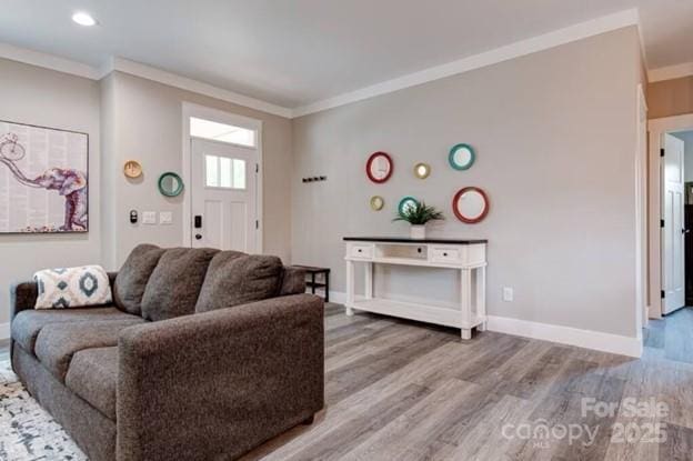 living room featuring ornamental molding, wood finished floors, and baseboards