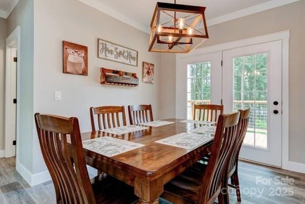 dining area with ornamental molding, baseboards, and wood finished floors