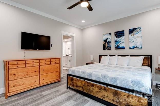 bedroom featuring baseboards, ensuite bathroom, crown molding, light wood-type flooring, and recessed lighting