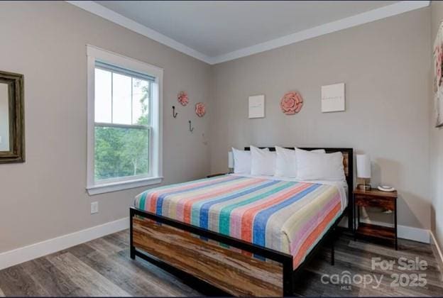 bedroom with baseboards, crown molding, and wood finished floors