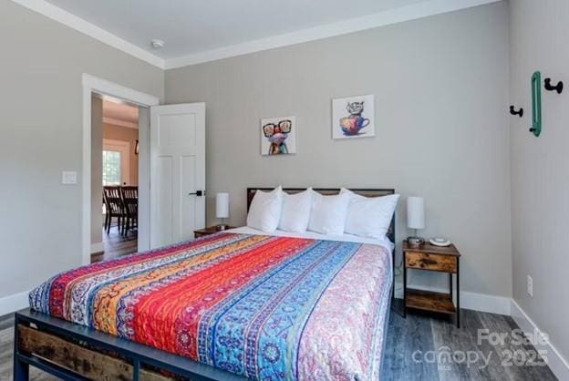 bedroom with crown molding, wood finished floors, and baseboards