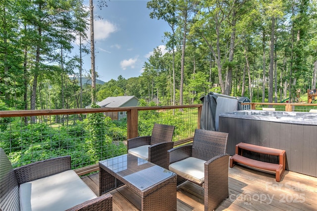 deck featuring a hot tub and a view of trees