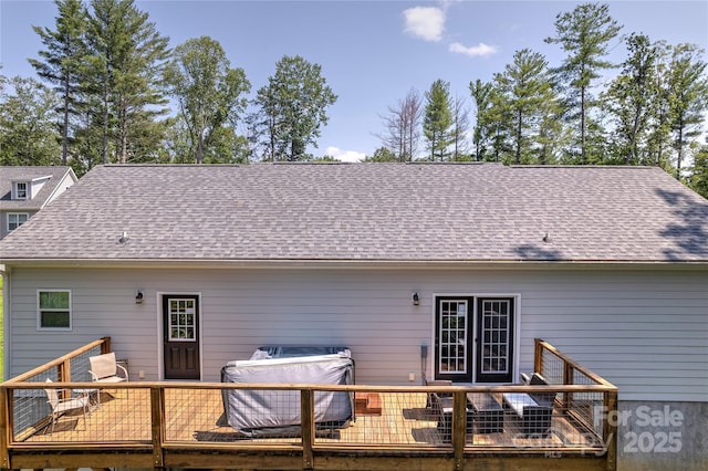 rear view of house with roof with shingles and a wooden deck