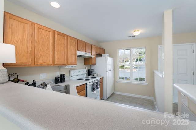 kitchen with light countertops, visible vents, a sink, white appliances, and under cabinet range hood