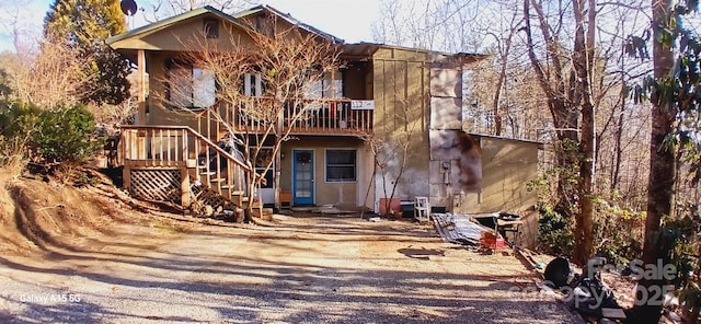 rear view of property featuring stairway and a wooden deck