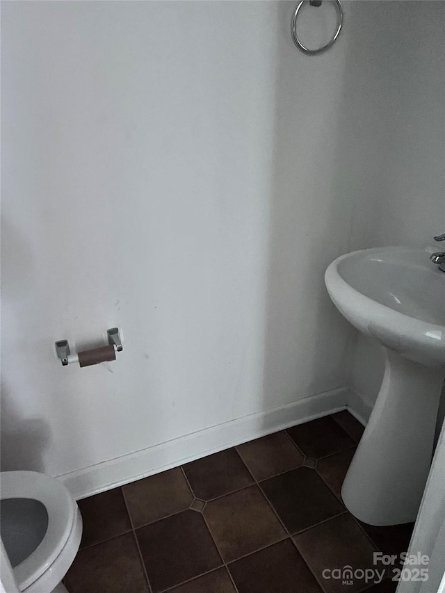 bathroom with tile patterned flooring, toilet, and baseboards