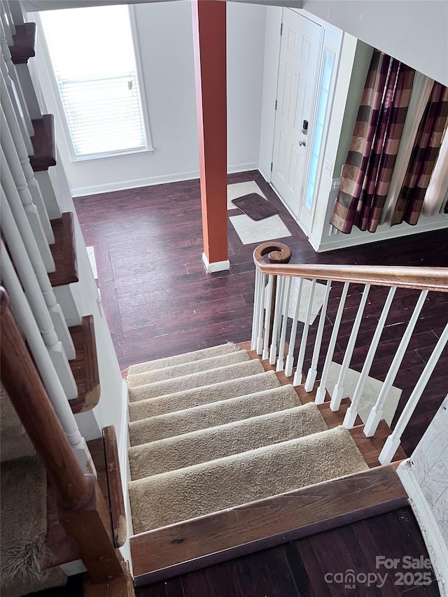 stairs with wood finished floors and baseboards