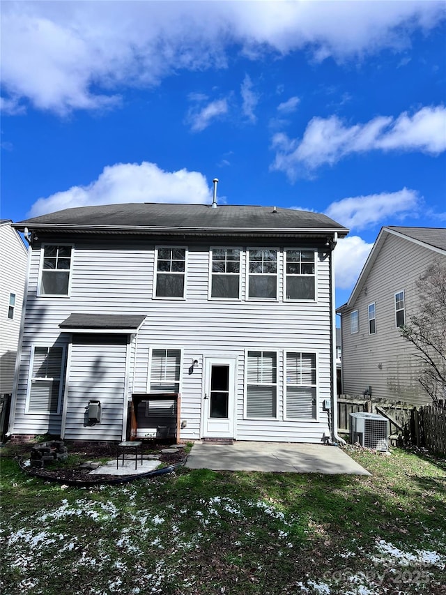 back of property with a jacuzzi, fence, a yard, a patio area, and central AC