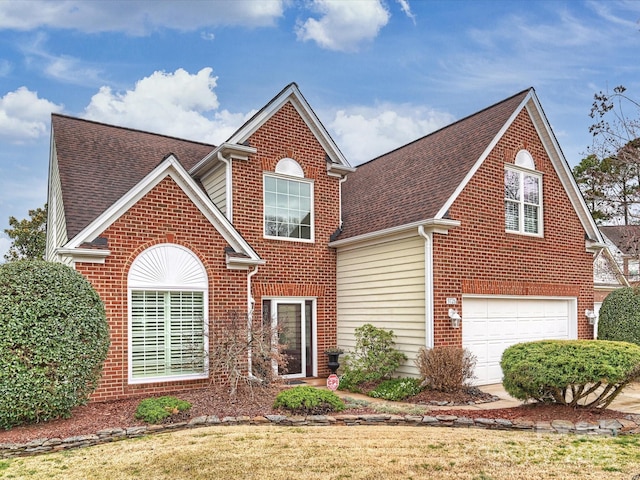 traditional home featuring a garage, brick siding, and a shingled roof