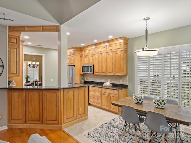 kitchen featuring decorative backsplash, recessed lighting, a peninsula, hanging light fixtures, and stainless steel appliances