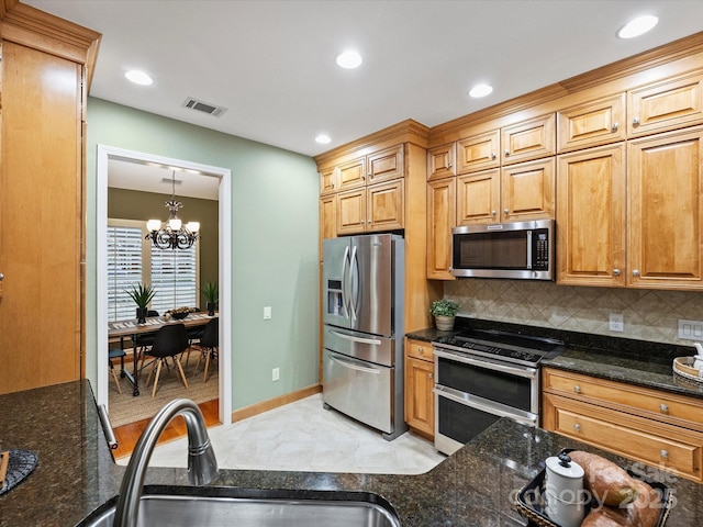 kitchen featuring decorative backsplash, visible vents, appliances with stainless steel finishes, and a sink