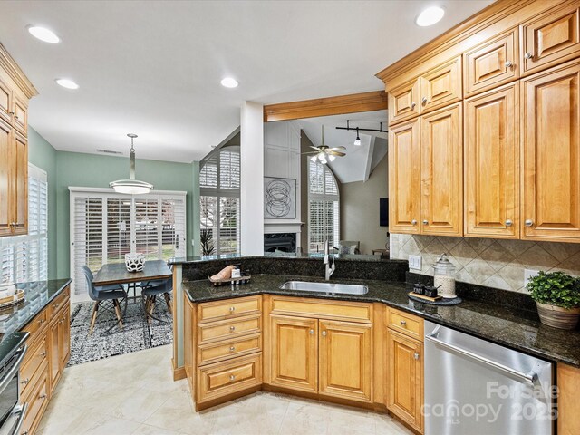 kitchen featuring a sink, backsplash, appliances with stainless steel finishes, a peninsula, and ceiling fan