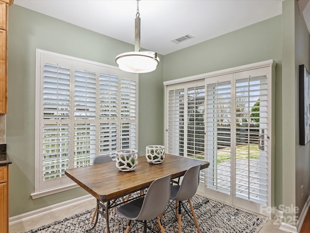 dining space featuring tile patterned floors, visible vents, and baseboards