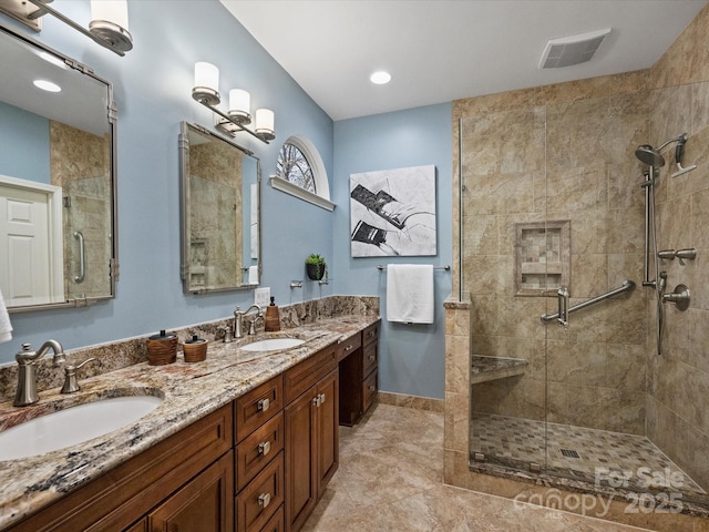 bathroom with double vanity, visible vents, a shower stall, and a sink