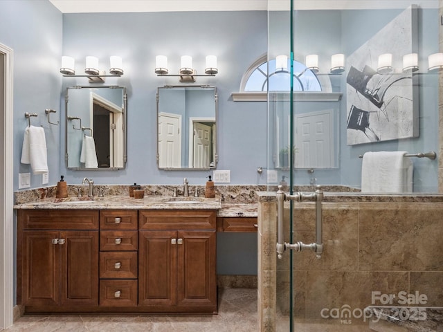 full bath with double vanity, a shower stall, and a sink