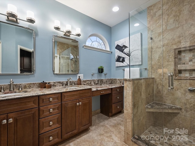 full bathroom featuring double vanity, a shower stall, and a sink