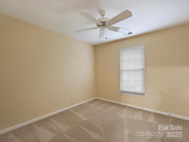 spare room with visible vents, a ceiling fan, baseboards, and light carpet