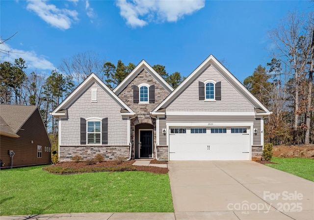 craftsman inspired home featuring stone siding, a front yard, and concrete driveway