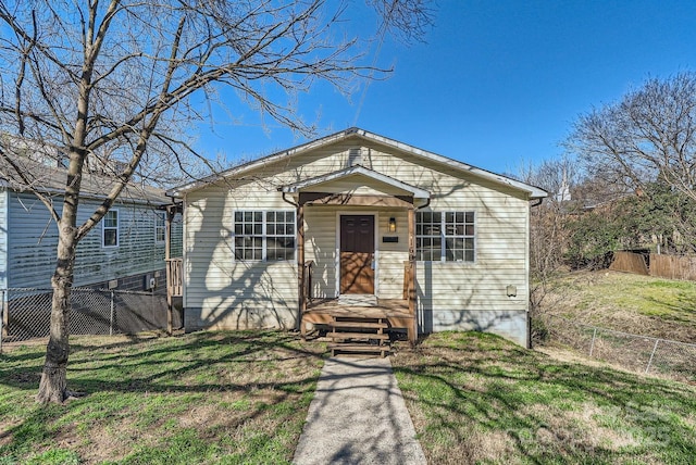 bungalow-style house featuring fence and a front yard