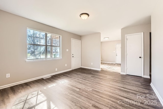 empty room with baseboards and wood finished floors