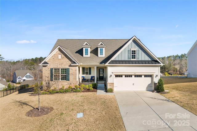 view of front of house with brick siding, concrete driveway, board and batten siding, fence, and a front lawn