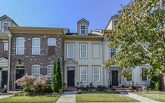 view of property with brick siding and a front yard