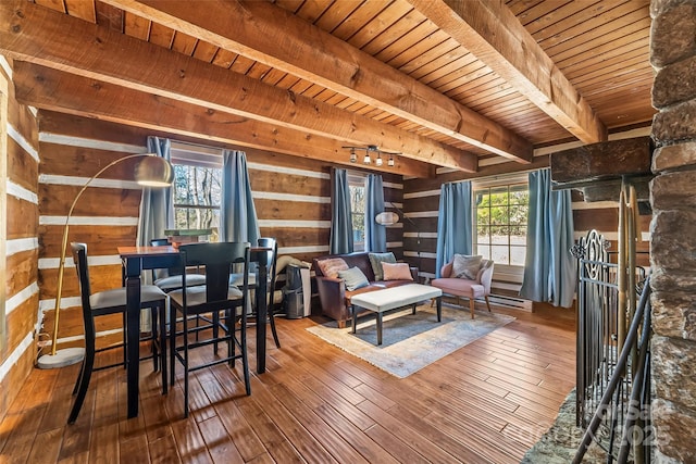 interior space featuring beam ceiling, wood walls, wooden ceiling, and hardwood / wood-style flooring