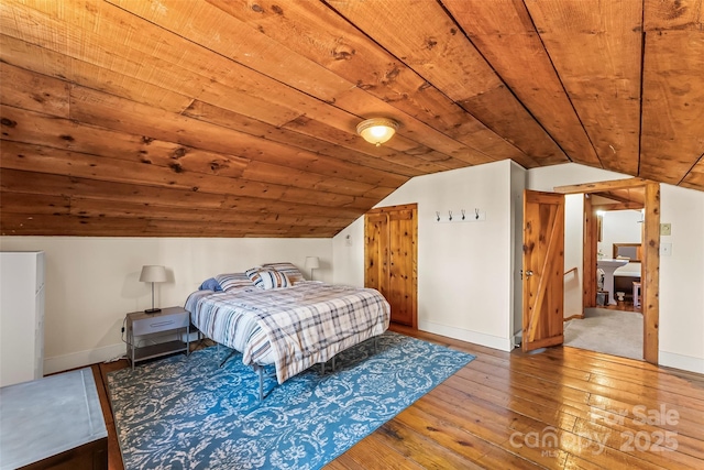 bedroom featuring wooden ceiling, baseboards, and hardwood / wood-style floors