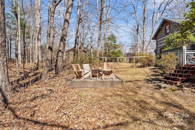 view of yard with an outdoor fire pit, a patio area, and fence