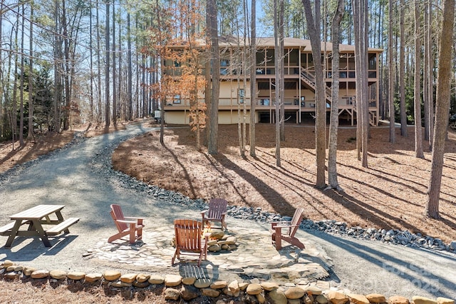 rear view of property featuring an outdoor fire pit, a patio, and stairway