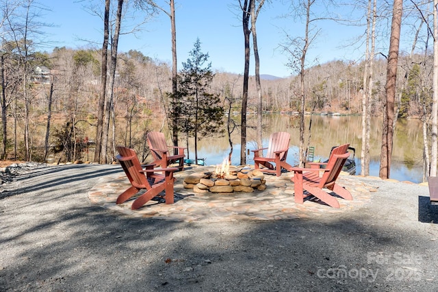 view of home's community with a fire pit and a forest view