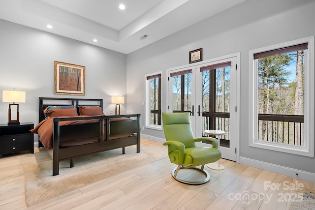 bedroom featuring access to exterior, recessed lighting, multiple windows, and light wood finished floors