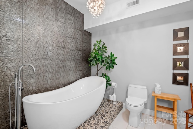 full bathroom featuring visible vents, toilet, a soaking tub, tile patterned flooring, and tile walls