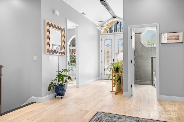 entryway featuring visible vents, wood finished floors, a wealth of natural light, and baseboards