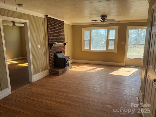 unfurnished living room with wood-type flooring, a ceiling fan, and baseboards