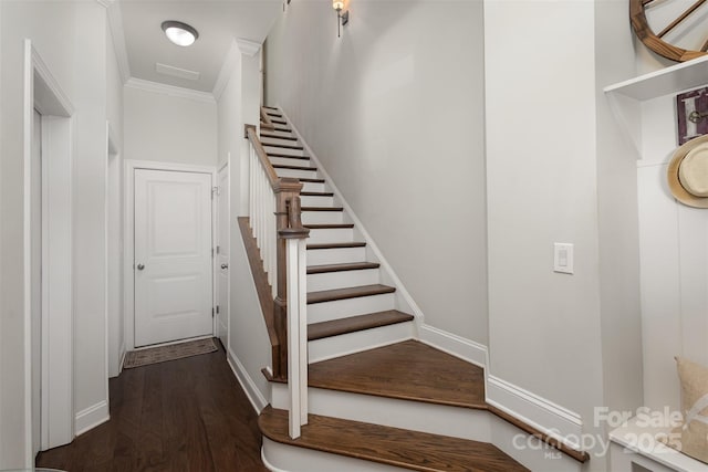 stairs with baseboards, ornamental molding, and wood finished floors