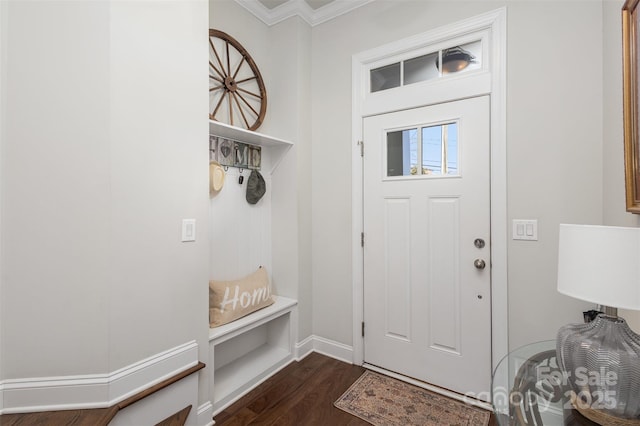 foyer featuring ornamental molding, dark wood-type flooring, and baseboards