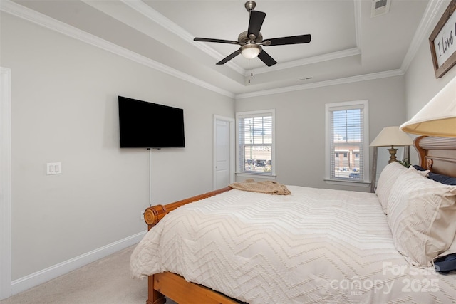 carpeted bedroom with a ceiling fan, visible vents, baseboards, a raised ceiling, and crown molding