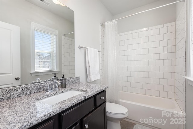 bathroom featuring visible vents, vanity, shower / bath combo with shower curtain, and toilet