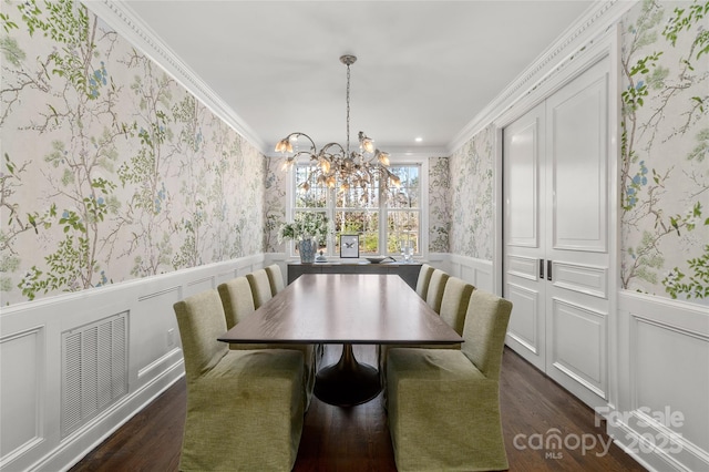 dining area featuring wallpapered walls, crown molding, and wainscoting