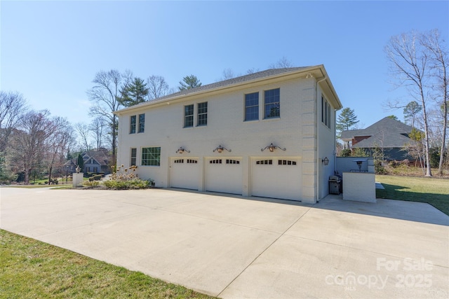 view of side of home featuring a garage and concrete driveway