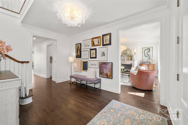 corridor with baseboards, crown molding, a chandelier, and wood finished floors