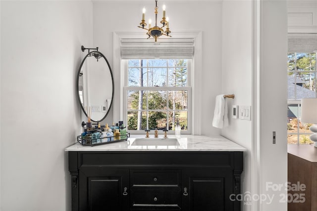 bathroom featuring a notable chandelier and vanity