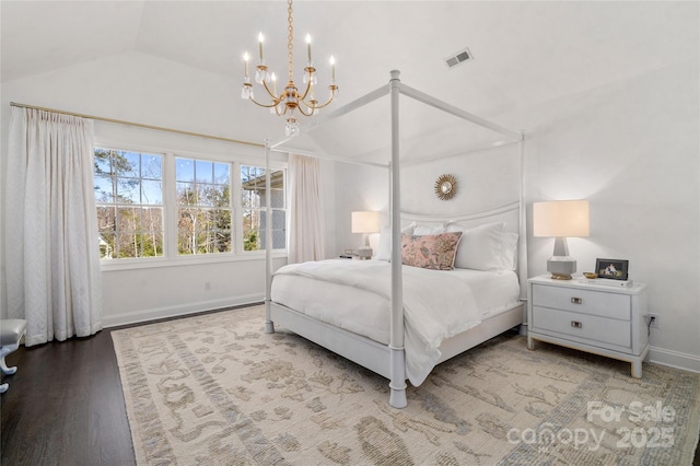 bedroom with wood finished floors, visible vents, baseboards, vaulted ceiling, and an inviting chandelier