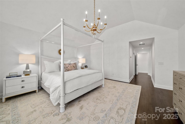 bedroom with baseboards, visible vents, vaulted ceiling, and wood finished floors