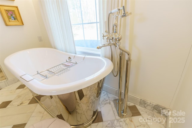 interior details with a soaking tub and baseboards