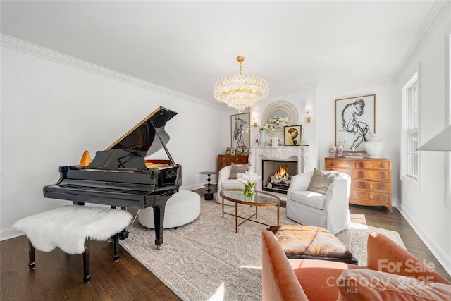 sitting room with a fireplace, wood finished floors, baseboards, an inviting chandelier, and crown molding