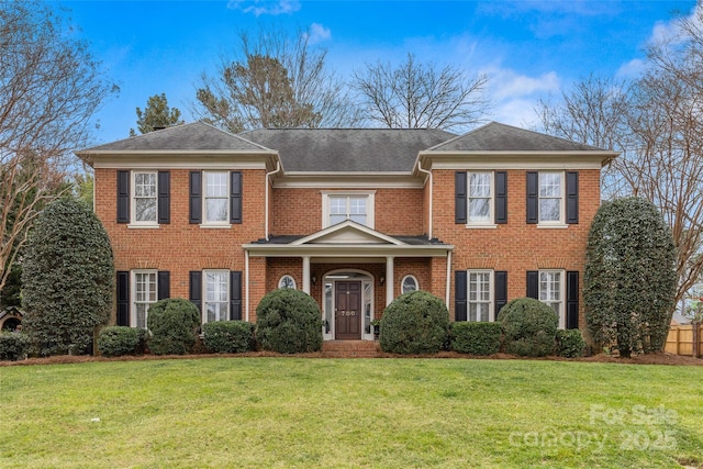 view of front of home with brick siding and a front yard