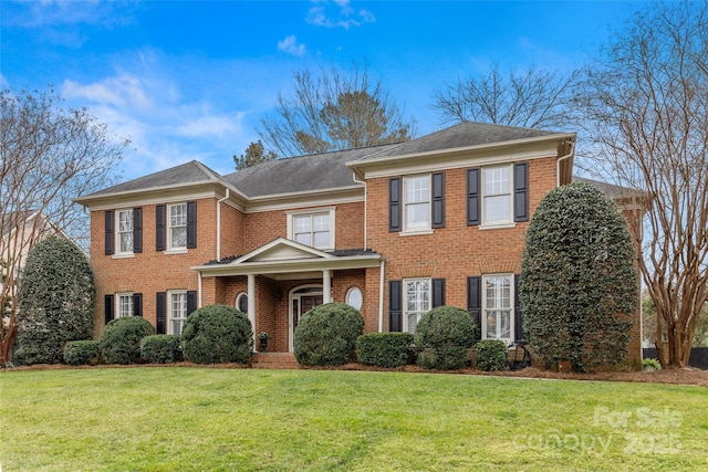 view of front of house with a front yard and brick siding