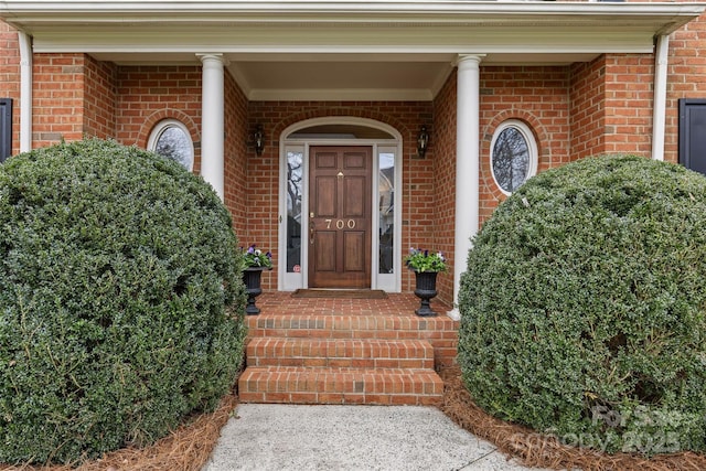 doorway to property featuring brick siding